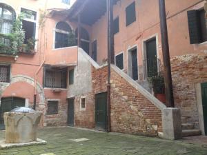 un antiguo edificio de ladrillo con una escalera en un patio en Ca' Botera, en Venecia