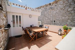 a patio with a wooden table and chairs at Apartman Marija in Betina
