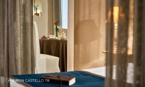a room with a table and a white chair and a window at Albergo Diffuso Birkin Castello in Cagliari