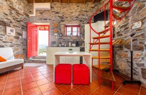 a living room with a red table and a spiral staircase at Casa do Feitor - Douro - Quinta da Cabrida in Sendim