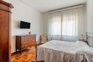 um quarto com uma cama, uma cómoda e uma televisão em Residenza Martinelli em Pistoia