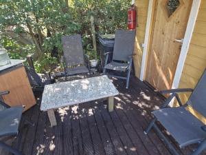 a group of chairs and a table on a deck at Hubane saunamaja sisehoovis in Tartu