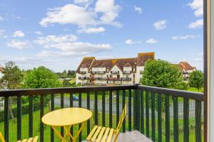 - un balcon avec une table et des chaises dans l'établissement Beautiful duplex with balcony in Cabourg - Welkeys, à Cabourg