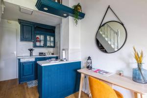 - une cuisine bleue avec une table et un miroir dans l'établissement Beautiful duplex with balcony in Cabourg - Welkeys, à Cabourg