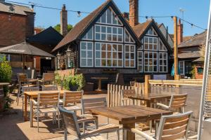 a restaurant with wooden tables and chairs in front of a building at The Crown Pub and Hotel in Manningtree