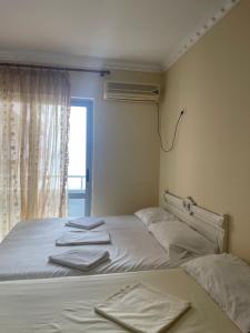 a bedroom with two beds with white sheets and a window at Almar Apartments in Durrës