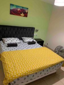 Un dormitorio con una cama con una manta amarilla. en Platinum Prestige Suit en Sarcelles