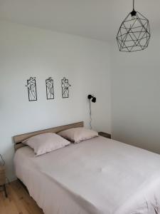 a bedroom with a large white bed with black drawings on the wall at La Grange - 10 couchages in Carla-de-Roquefort