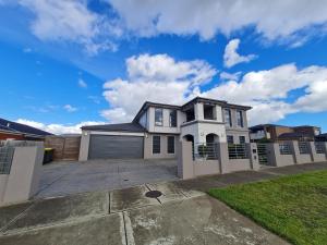 a large white house with a garage at Stylish House in Geelong for Large Family or Group in Geelong