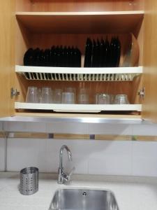 a kitchen with a sink and a shelf with utensils at Piso en San Fernando (Cádiz) in San Fernando