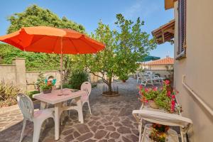a patio with a table with an umbrella and chairs at La Casa di Lisa in San Vincenzo