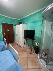 una camera con letto, televisore e tavolo di Casa Ortu a Milis