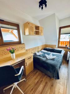 a bedroom with a bed and a desk and a chair at Domek Giewont in Zakopane