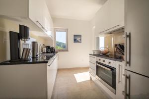 cocina con encimeras blancas y fogones en Villa Sabine Apartment Cres, en Medveja