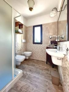 a bathroom with two sinks and a toilet and a shower at Agriturismo il Pianetto in Principina Terra +20 photos