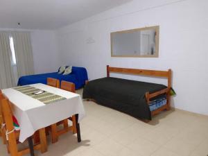 sypialnia z łóżkiem, stołem i lustrem w obiekcie Departamentos el Peregrino w mieście San Luis