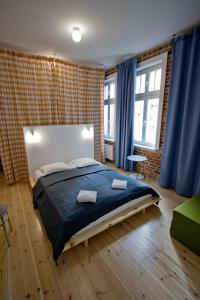 een slaapkamer met een groot bed en blauwe gordijnen bij New Port Apartment Gdańsk in Gdańsk