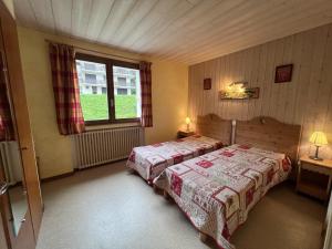 a bedroom with two beds and a window at Gemeaux B, appartement proche pistes de ski et village NOUVEAU A LA LOCATION in La Clusaz