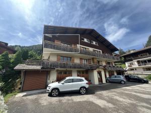 a white car parked in front of a building at Gemeaux B, appartement proche pistes de ski et village in La Clusaz