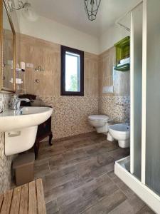 łazienka z 2 umywalkami, wanną i toaletą w obiekcie Agriturismo il Pianetto w mieście Principina Terra