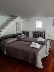 two beds with towels on top of them in a room at loft giulia in Bari