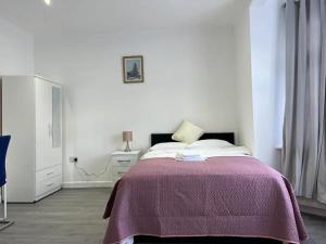 Säng eller sängar i ett rum på Remarkable 2-Bed Apartment in Ilford London