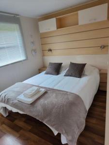 Un dormitorio con una cama grande y una bandeja. en Les chalets Salinéens en Salies-du-Salat