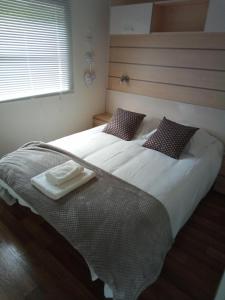 een slaapkamer met een groot wit bed en een dienblad bij Les chalets Salinéens in Salies-du-Salat
