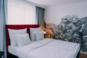una camera da letto con un letto bianco con testiera rossa di Anaberg a Nowa Ruda