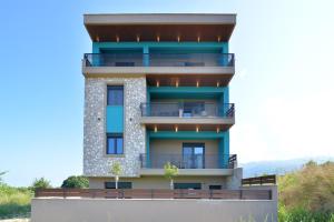 un edificio con balcones en un lateral en Niel Holiday Apartments, Panel Hospitality Homes & Villas en Leptokarya
