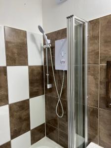 a bathroom with a shower with a shower head at Remarkable 1-Bed Studio Apartment in Redbridge in Ilford