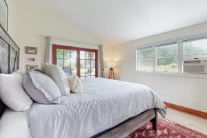 - une chambre blanche avec un lit doté de draps blancs et de fenêtres dans l'établissement The Adams Mill Farm House, à Stowe