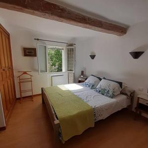 a bedroom with a bed in a room with a window at Maison dans un village du Var avec jardin in Seillans