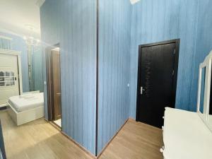 a bathroom with a mirror and a blue wall at HOTEL AiSi აისი in Kutaisi