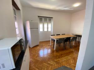波尔图BREINER 54的配有桌子和冰箱的厨房和餐厅