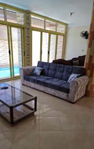 uma sala de estar com um sofá azul e uma mesa de vidro em فيلا 110 قريه سلاح المهندسين em Alexandria