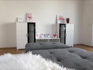 a bedroom with a large bed and two white cabinets at Moderne Alpenblick Apartment in Friedrichshafen