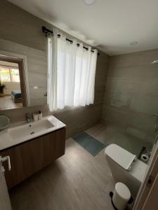 een badkamer met een wit toilet en een wastafel bij Casa Mulata Coral Village Pool & Playa 2 in Punta Cana