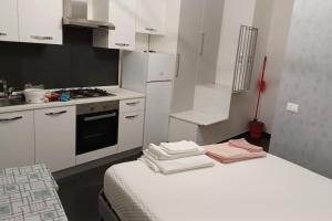 a small kitchen with white cabinets and a stove at Studio Flat Verona 1 balcone in Verona