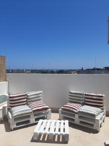 2 chaises longues assises au-dessus du toit dans l'établissement loft giulia, à Bari