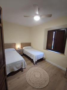 una camera con due letti e un tappeto di Apartamento Real 17, Cádiar a Cádiar