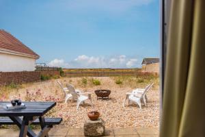 a view of a patio with chairs and a table at The Buoys in Dungeness