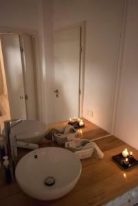 a bathroom with a sink and a toilet and candles at Retro MidTown Apartment in Bucharest