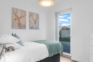 a white bedroom with a bed and a window at Contractor Accommodation 4 Bedroom House Sleeps 7 Free Van Parking Near Avonmouth Docks in Avonmouth