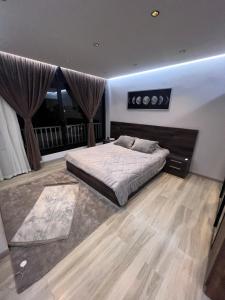 a bedroom with a large bed and a large window at Zamalek Skyline Condo in Cairo