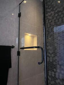 y baño con ducha y puerta de cristal. en Zamalek Skyline Condo en El Cairo