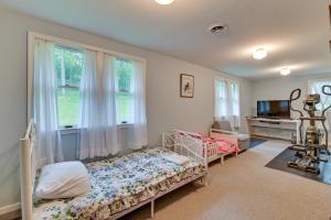 a bedroom with a bed and a window and a television at Spacious Canandaigua Lake House with Dock and Kayak! in Canandaigua