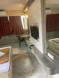 Cette chambre dispose d'une télévision, d'un lit et d'un canapé. dans l'établissement Calangute Beach Way, à Calangute