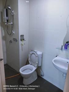 La salle de bains est pourvue de toilettes et d'un lavabo. dans l'établissement Rafa Vista Homestay, à Shah Alam