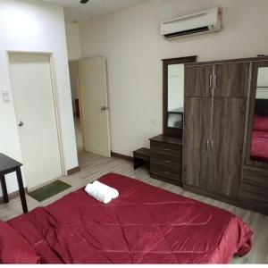 een slaapkamer met een rood bed en een spiegel bij Rafa Vista Homestay in Shah Alam